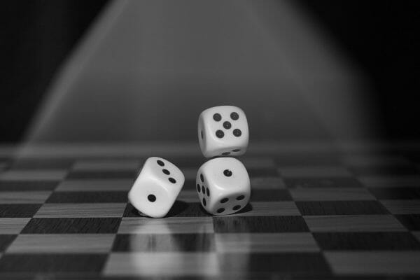 Black & white picture with dice falling onto a chess board