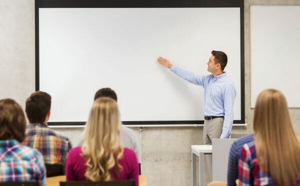 Man teaching at a projector screen